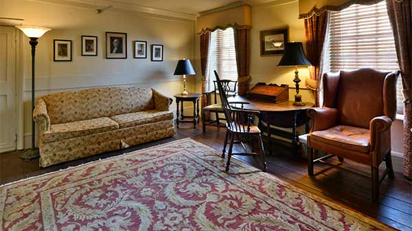The Washington Suite: A living room with antique furniture, sofa, and armchair.