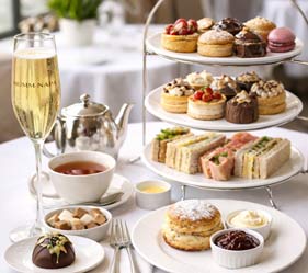 Elegant afternoon tea spread with sandwiches, pastries, and champagne.