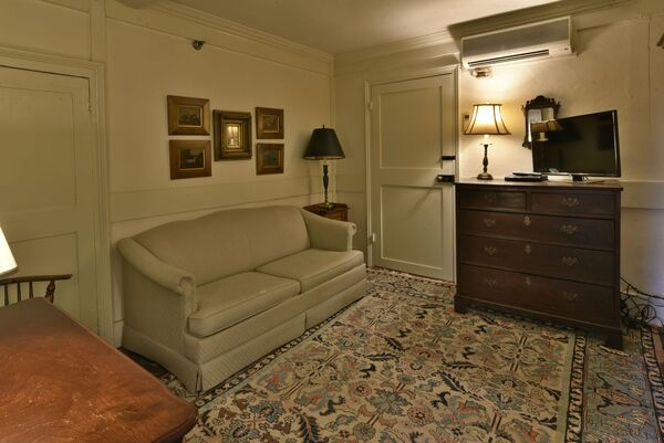 Jefferson Suite living area with sofa, dresser, and TV.