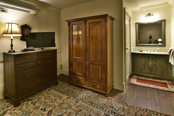 The Jefferson Suite: Antique armoire and dresser in a bedroom with ornate rug.