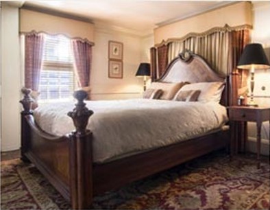 Elegant wooden bed with white sheets and pillows in a cozy bedroom