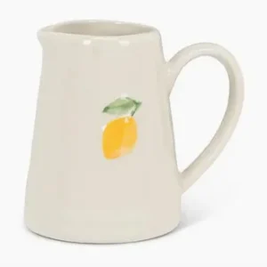 White ceramic jug with lemon design and leaf on a white background