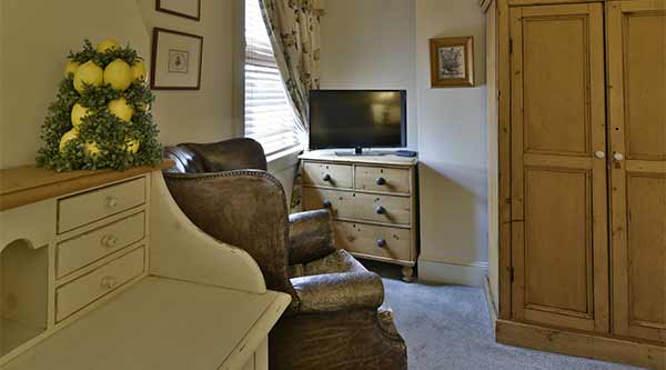 The Mary Reynolds Room: Antique desk, leather chair, and dresser with lemon decor