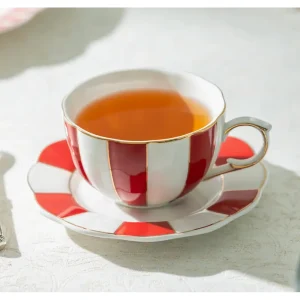 Red and white scallop fine porcelain tea cup and saucer with tea