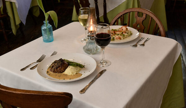 Elegant dinner setting with steak, asparagus, mashed potatoes, and wine